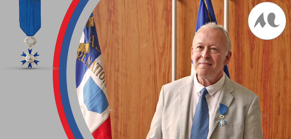 Portrait gros plan de Laurent Coste portant la médaille de Chevalier de l'Ordre du Mérite sur sa veste de costume. . 