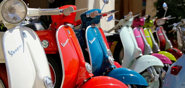 Plusieurs Vespas sont alignés en ville