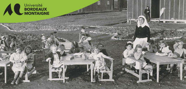 Enfants et religieuse dans un camp d’internement en Aquitaine entre 1938 et 1948, devant plusieurs baraquements du camp.